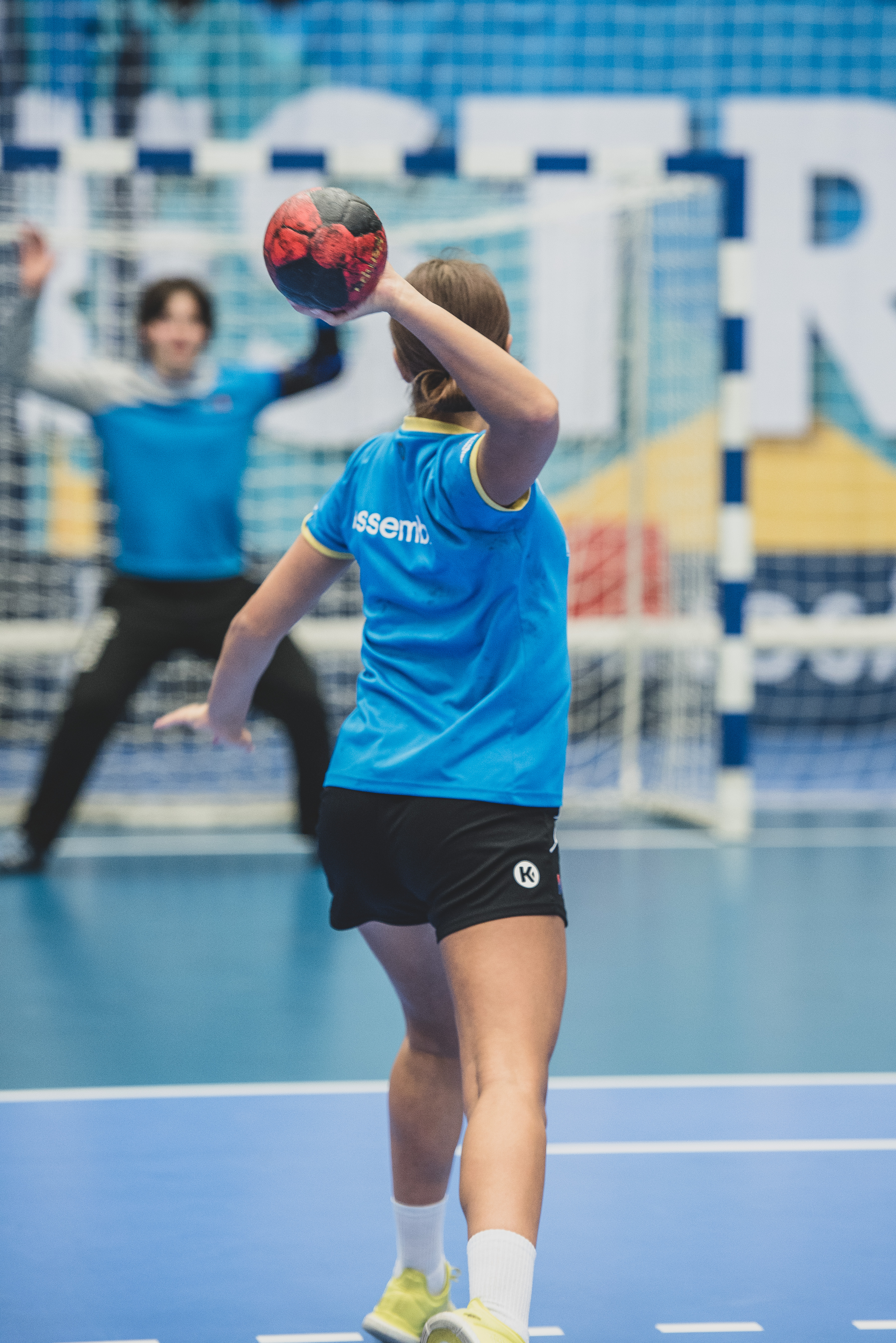 en handbollsspelare kastar en boll mot mål