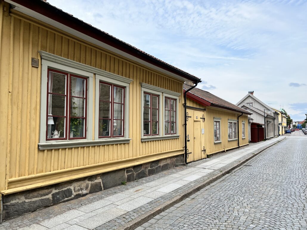 Gult trähus på kullerstensgatan Drottninggatan i Alingsås centrum.