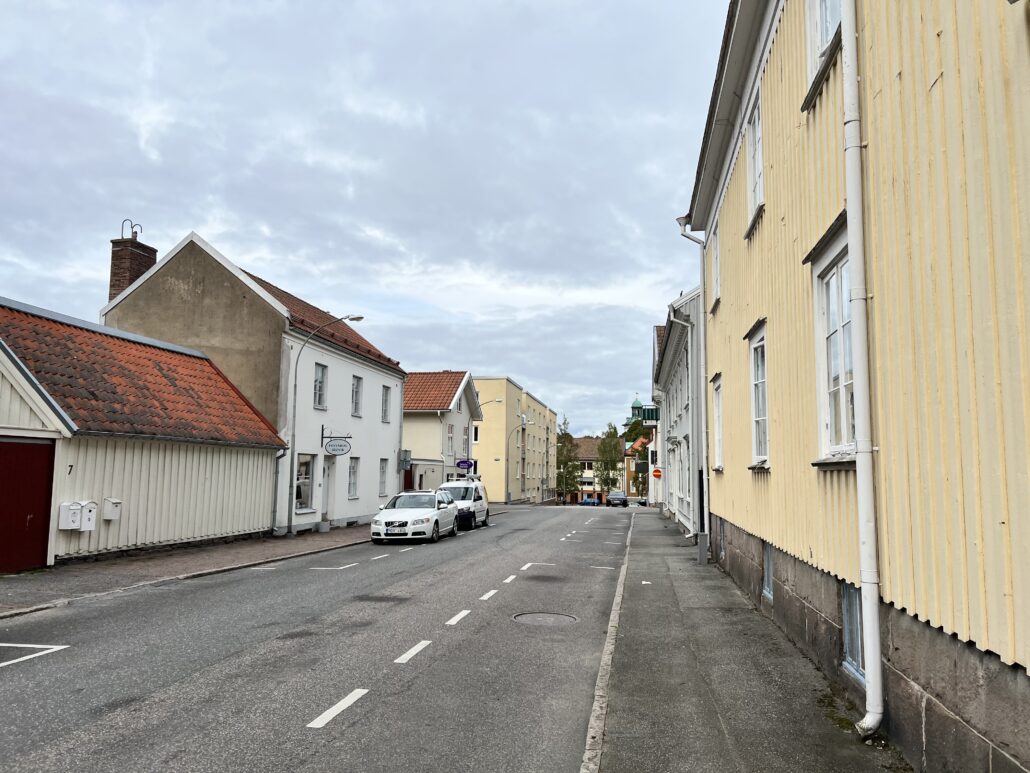 Gata i centrala Alingsås med trähus längs med sidorna i vitt och gult.