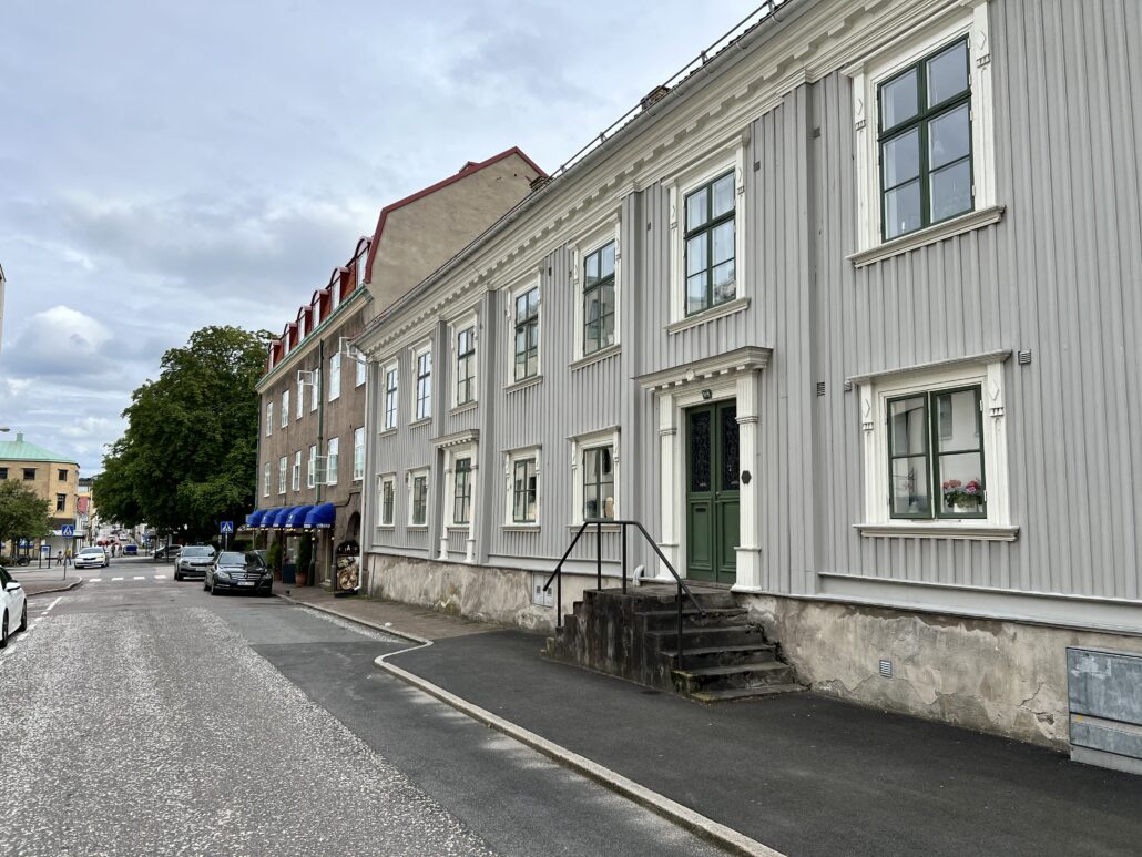 Grått trähus med grön ytterdörr i Alingsås stadskärna.