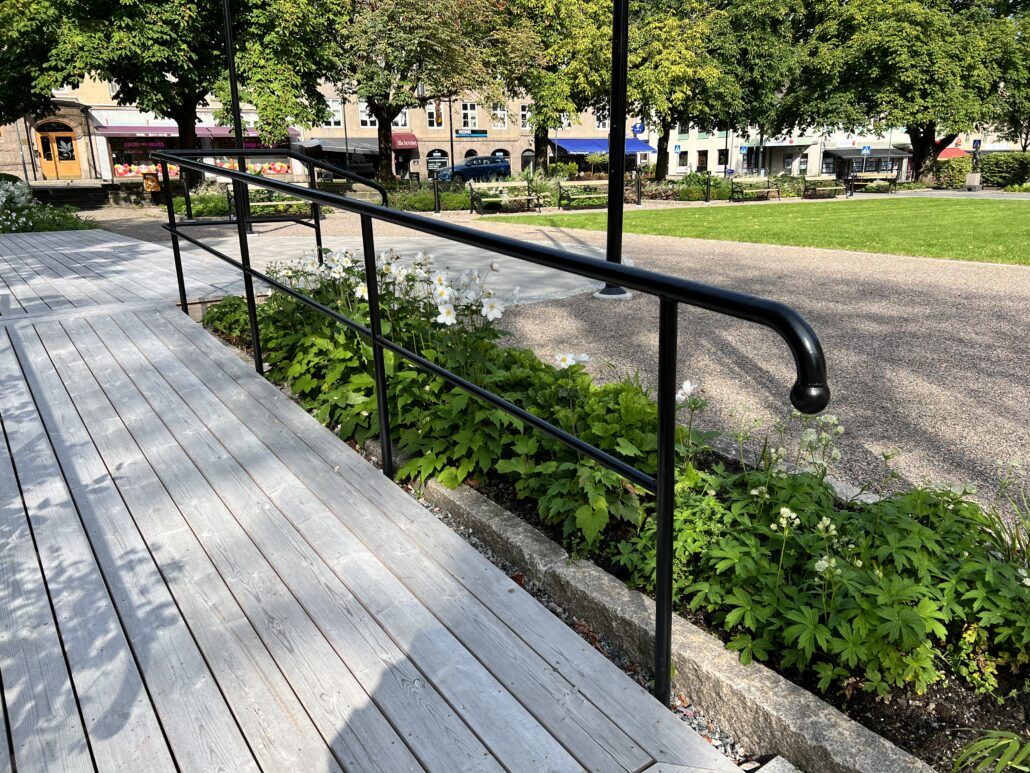 Museiparken i Alingsås stadskärna med fokus på ett svart räcke.