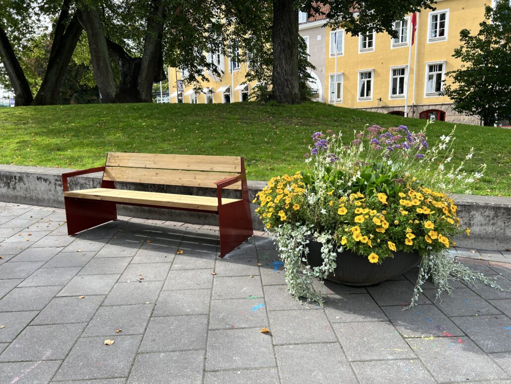 Soffa Bloc i Åmanska parken med en fin blomsterkruka bredvid.