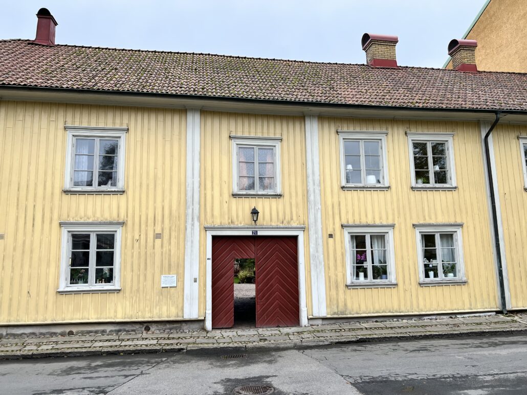 Gul träfasad vid entrén till Nattsénska gården vid Lilla torget i Alingsås stadskärna.