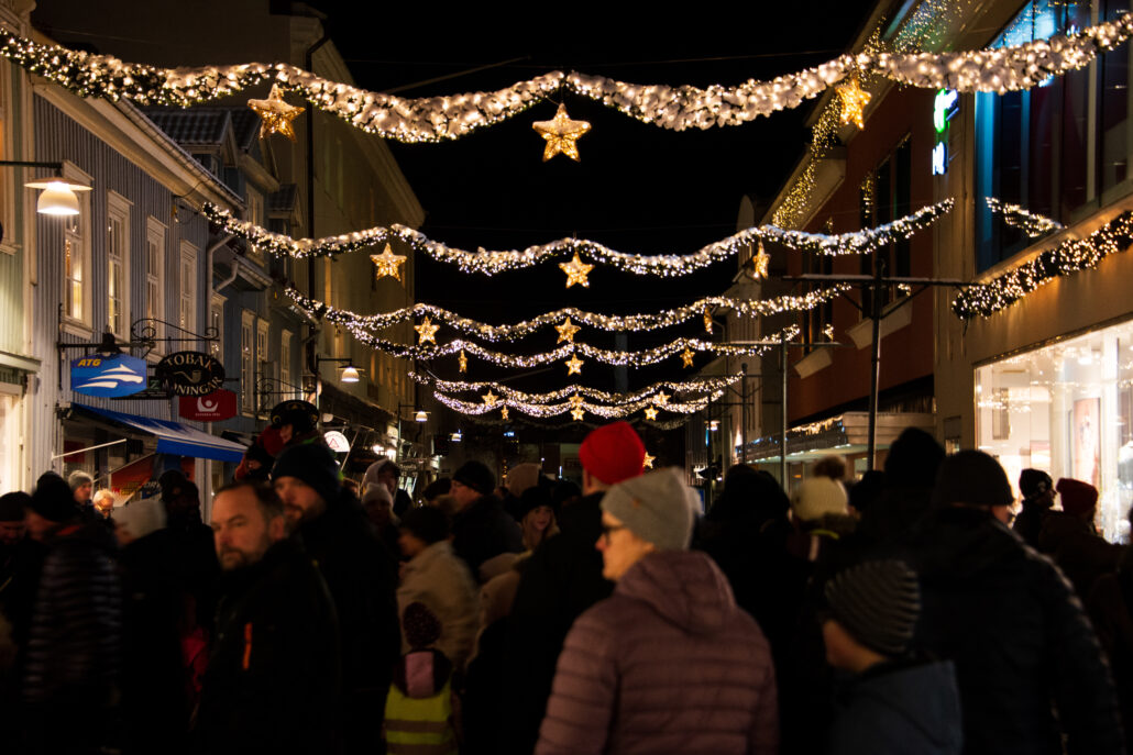 Tomteparaden, första advent på Kungsgatan i Alingsås stadskärna. Lysande girlanger med stjärnor hänger mellan husen och människor tågar på gatan.